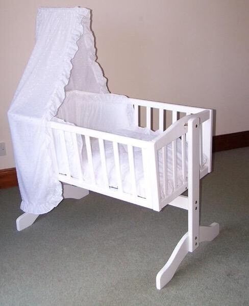 white swinging crib with drapes